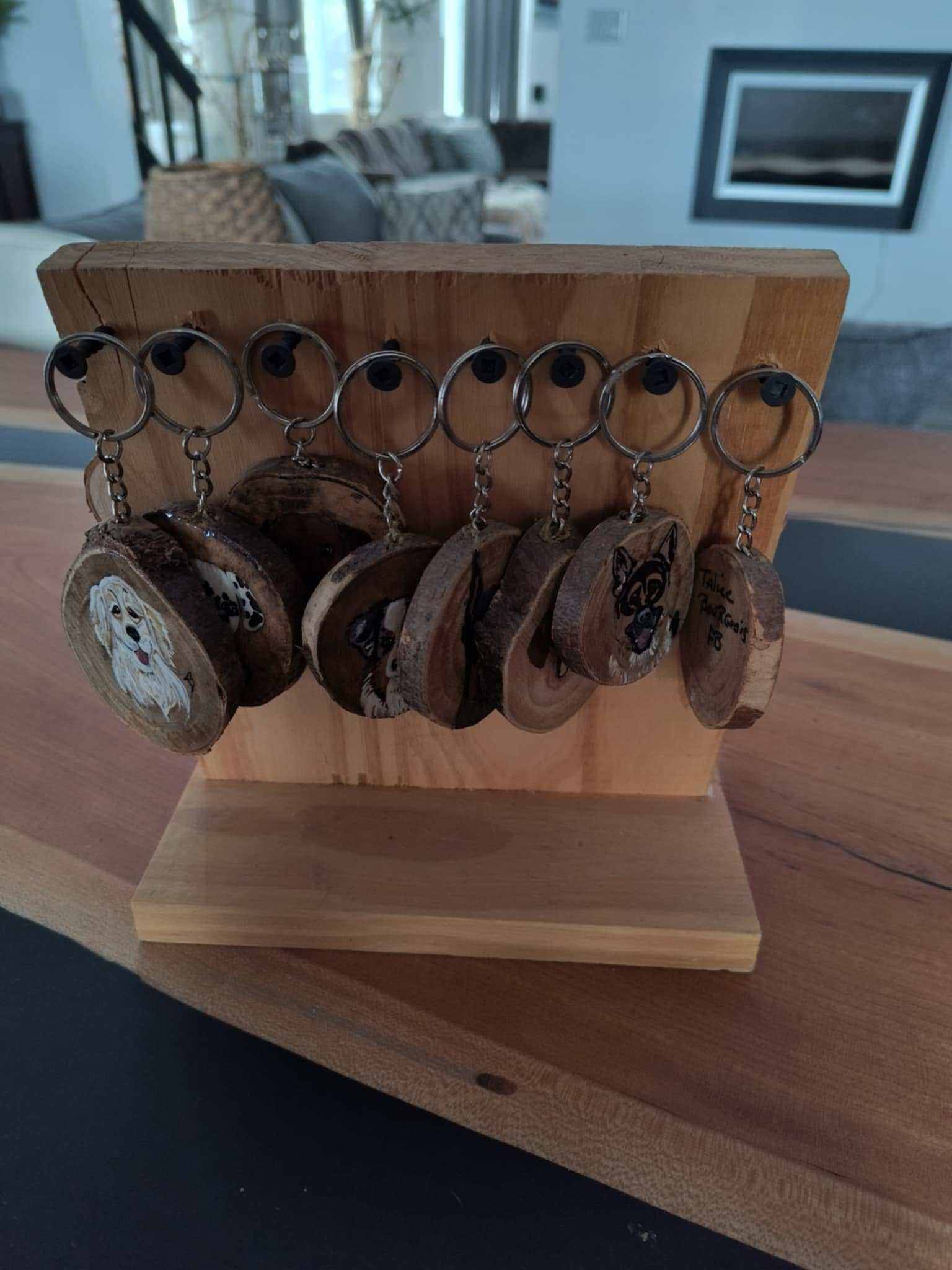 Handmade wooden keychains by La Boite D Art A Talie, featuring unique hand-painted designs on display.