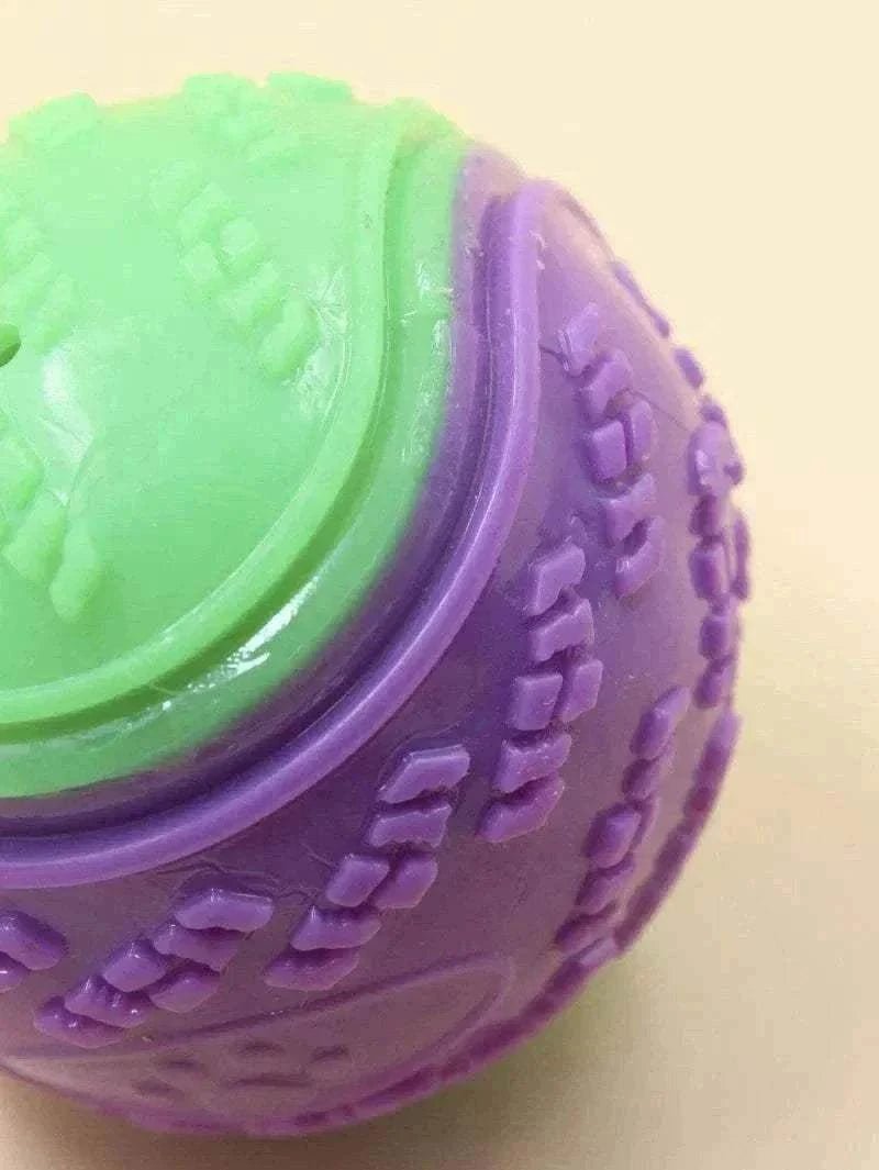 Balle mâchouillable en TPR bicolore verte et violette pour chiens avec texture pour nettoyage dentaire et jouet sonore interactif.